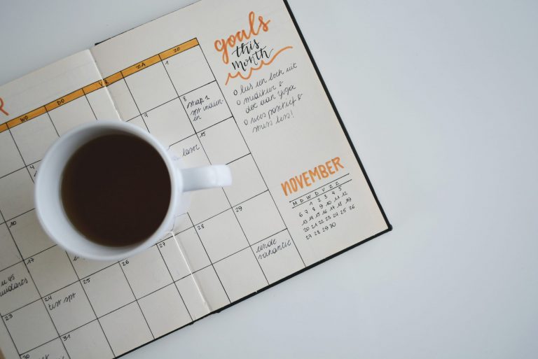 Paper planner with montly calendar drawing and a cup of coffee