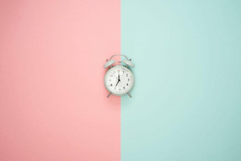 Alarm clock in a pink and blue background