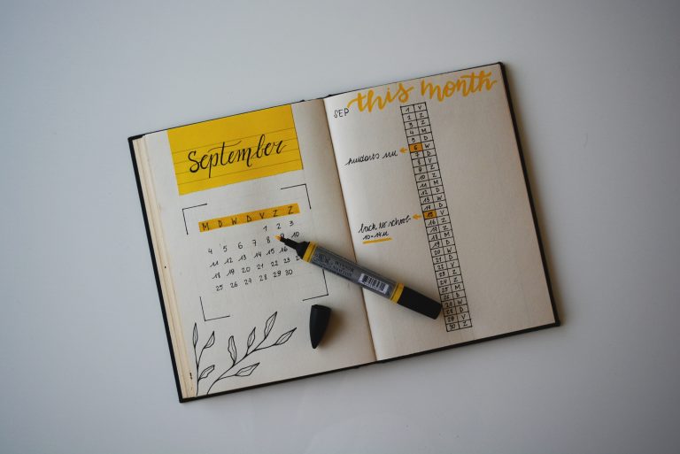 Paper planner or journal with calendar and habit tracker drawings to show daily planner app