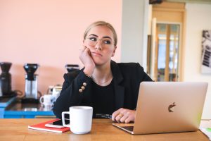 Woman working and thinking how to avoid procrastination in the workplace